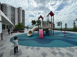 a child standing in a playground with a slide at InapByDaddy's Near KLIA SIC Sepang 4BR Fully Aircond in Sepang