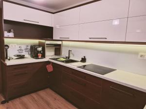 a kitchen with white cabinets and a sink at Vila Hafira in Zuberec