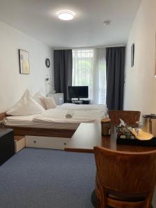 a bedroom with a bed and a desk and a table at Hotel Restaurant Toscana in Bad Orb