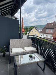 a balcony with a bench and a glass table at Hotel Restaurant Toscana in Bad Orb