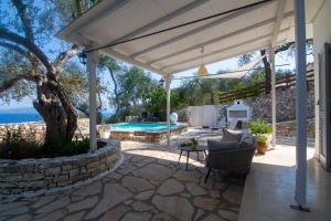 a patio with a pergola and a swimming pool at New! Paxosblue suites sea view with private pool in Gaios