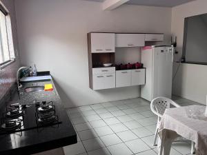 a kitchen with a black counter and a white refrigerator at Casa na nova maraba in Marabá +12 photos