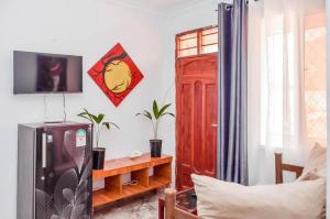 a living room with a refrigerator and a red door at Kilifi Tulivu in Kilifi +3 photos