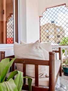 a wooden chair with a pillow in front of a window at Kilifi Tulivu in Kilifi