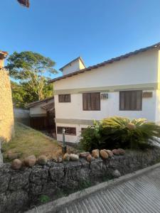 a house with a stone wall in front of a house at Casa Country Niterói in Niterói