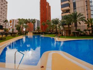 a large swimming pool in a city with tall buildings at Apartamento Gema Gemelos 26 in Benidorm