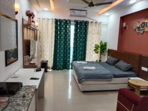 a bedroom with a bed and a desk in it at Kremlin Luxury Studios in Ghaziabad