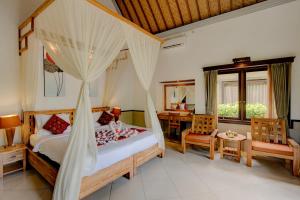 a bedroom with a canopy bed and a table and chairs at Dupa Ubud in Ubud +59 photos