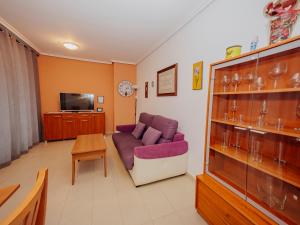 a living room with a purple couch and a tv at Apartamento Gema Gemelos 26 in Benidorm