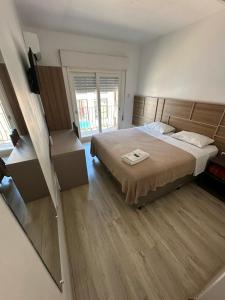 ein Schlafzimmer mit einem großen Bett und Holzböden in der Unterkunft Veneto Hotel in Canguçu