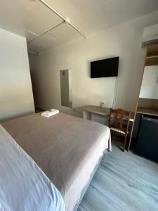 ein Schlafzimmer mit Bett, Schreibtisch und Fernseher in der Unterkunft Veneto Hotel in Canguçu + 39 Fotos