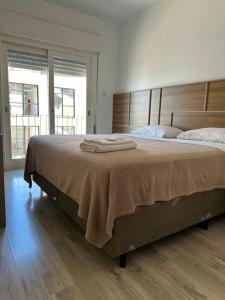 ein Schlafzimmer mit einem großen Bett, auf dem zwei Handtücher liegen in der Unterkunft Veneto Hotel in Canguçu