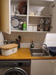 a kitchen counter with a sink and a washing machine at Self contained 1 bedroomed garden flat in Abersychan +2 photos