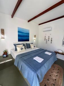 a bedroom with a large bed with a blue blanket at BaleiaLofts Kite Village in Itapipoca +42 photos