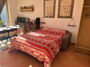 a bedroom with a bed with a red blanket on it at Pulsà dol Sìndec in Vilminore