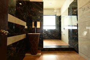 a bathroom with black marble walls and a window at Rudrakshi Inn in Mount Ābu +44 photos