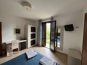 a room with a bed and a desk and a television at B&B Agrodolce in San Vito lo Capo