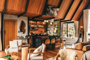 a living room with a couch and a kitchen with a tub at Chalé RIVAGI in Passa Quatro
