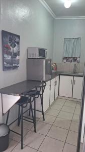 a small kitchen with a table and a microwave at Oppihoek Gastehuis in Kroonstad