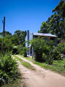 a dirt road next to a house with flowers at La Casa de Lili in La Pedrera
