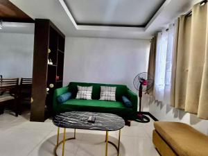 a living room with a green couch and a table at Ecowest Condo beside SM Mall in Davao City +139 photos