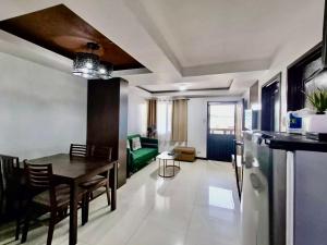a kitchen and living room with a table and a couch at Ecowest Condo beside SM Mall in Davao City