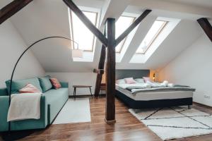 a attic bedroom with a bed and a couch at Apartmá Oberleithnerův palac in Šumperk +21 photos