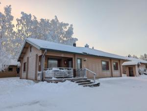 a house with snow on the ground in front of it at Matkailumaja Heikkala Cottages in Ruka