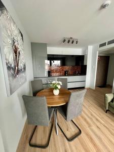 a kitchen and dining room with a wooden table and chairs at SPV Rentals Pileckiego 59 lokal 226 free Parking Ursynów in Warsaw
