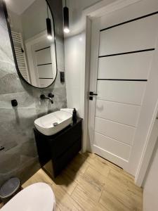 a bathroom with a toilet and a sink and a mirror at SPV Rentals Pileckiego 59 lokal 226 free Parking Ursynów in Warsaw