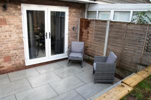 a patio with two chairs and a table at Stylish 4 Bed House, Free Parking, Close to M4 Newport in Newport