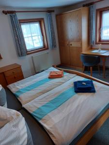 a bedroom with a large bed and a desk at Apartment Voithofer in Wald im Pinzgau