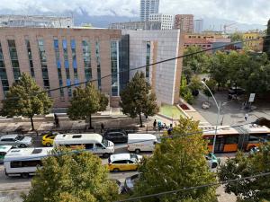 a city with buses and cars in a parking lot at Prime Location - shared Bath in Tirana