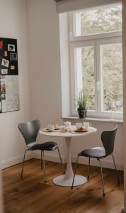 a white table with two chairs and a table with food on it at Freytag im Uni-Viertel in Duisburg