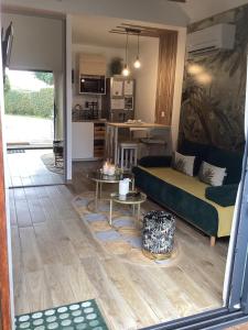 a living room with a couch and a kitchen at Guest house arboré in Saint-Loubès