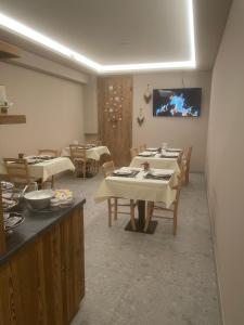a dining room with tables and a tv on the wall at Limes Alpine Rooms in Livigno