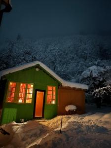 a green house in the snow at night at Dzveli kokhi in Utsera