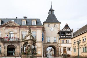 a building with a clock tower on top of it at L'Escapade Etoilée Rosheim in Rosheim