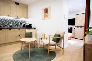 a living room with two chairs and a kitchen at L'Escapade Etoilée Rosheim in Rosheim