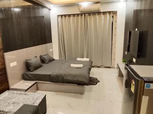 a bedroom with a bed and a television in it at Kremlin Luxury Studios in Ghaziabad