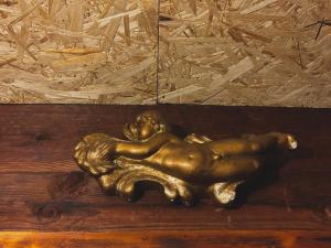 a bronze lion laying on a wooden table at Dzveli kokhi in Utsera +1 photo
