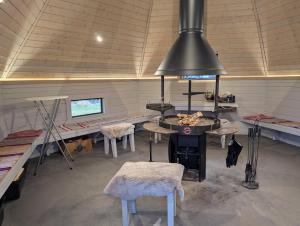 a garage with a room with tables and chairs and a stove at Matkailumaja Heikkala Cottages in Ruka