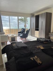 a bedroom with a bed with a view of the ocean at voya hotel and suites in Soûr