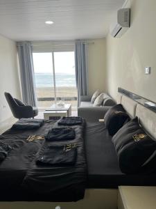 a bedroom with a bed with a view of the beach at voya hotel and suites in Soûr