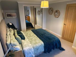 a bedroom with a bed with a blue comforter at The Place in Johnshaven