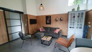 a living room with a couch and a table at Luxe vakantiebungalow Rust, Ruimte en Privacy in Dirkshorn