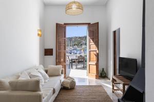 a living room with a white couch and a television at Ca Sa Joia - Beautiful Views in Port d'Andratx