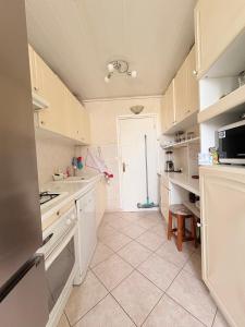 a kitchen with white cabinets and a sink and a door at Chambres chez l'habitant in Meudon