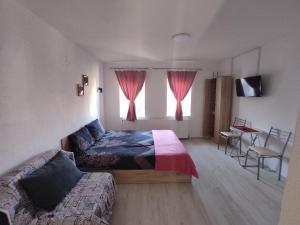 a bedroom with a bed and a couch and a window at Villa DIJA in Kruševo