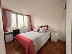 a bedroom with a bed and a desk and window at Chambres chez l'habitant in Meudon